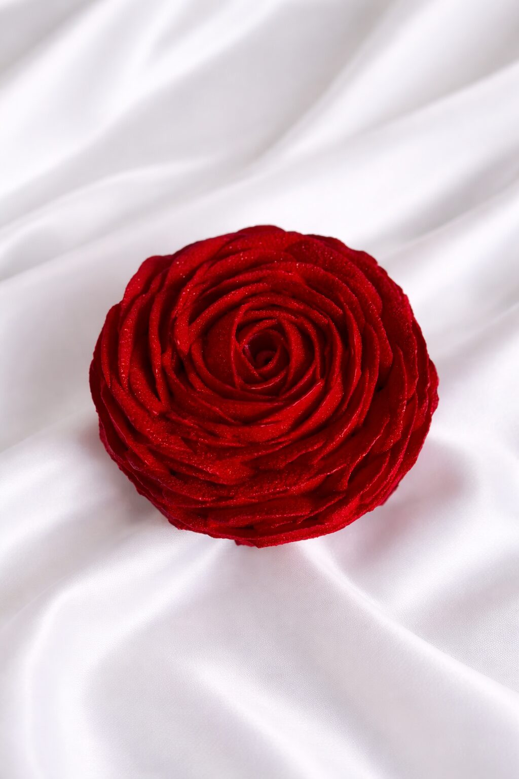 Fleur rouge en tissu sur un fond de satin blanc, Kumo Toulouse.