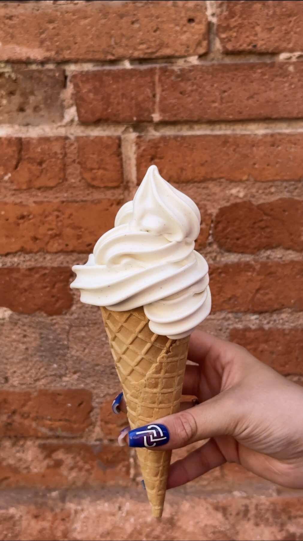 Crème glacée en cornet devant un mur en brique, Kumo Toulouse.